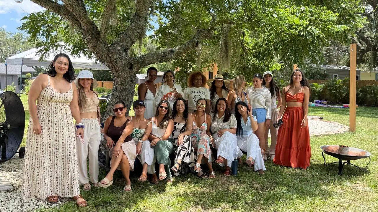 Grupo de mujeres posando juntas bajo un árbol en el jardín durante la primera edición de Renacer Retreat